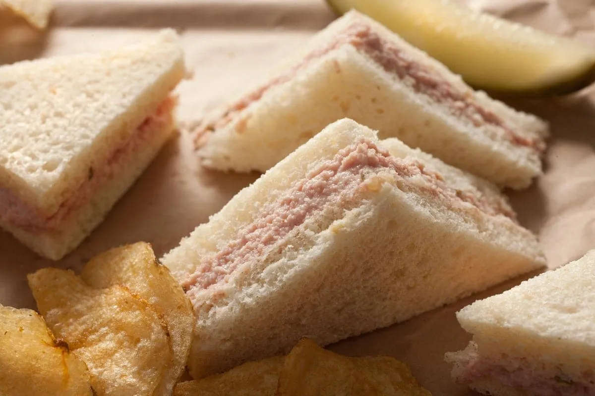 A nice luncheon ham spread which is served as a cheese ball with egg wedges and dill pickles surrounding it