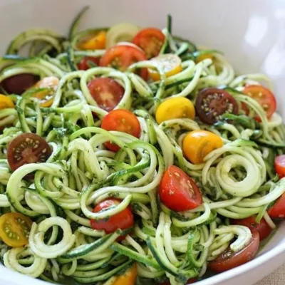 Raw Spiralized Zucchini Noodles With Tomatoes And Pesto