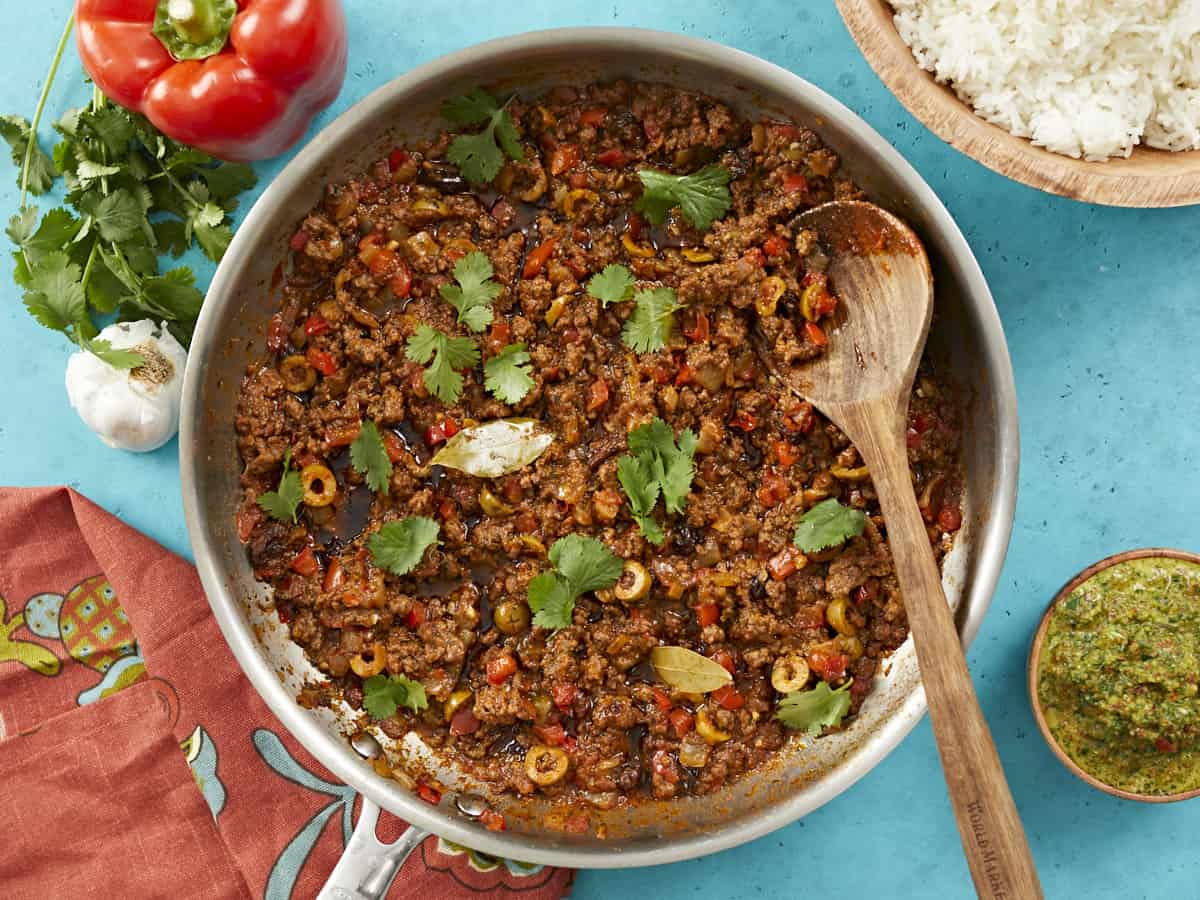 Picadillo is a ground meat hash with vegetables. It usually has capers and green olives in it as well. This recipe may be served over rice or used as a filling for sweet peppers